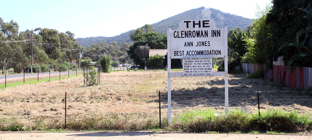 Along the Hume Highway, forty-five kilometres from Benalla, is the site of the Kelly Gang’s last stand, Glenrowan. Named after pioneer pastoralists James and George Rowan, who occupied pastoral stations between 1846 and 1858 in the area between Winton and Glenrowan, north of the township are the Warby Ranges, which provide run–off for some agricultural pursuits and for the filling of Lake Mokoan, east of Glenrowan. Formerly a swamp, the lake was artificially formed in 1970. The railway line through Glenrowan was opened in 1873, two years before town allotments were put up for sale and three years before the primary school was opened. In 1880, Glenrowan was the site of the siege of the Kelly Gang at Jones Hotel. The gang's leader, Ned Kelly, had calculated that police would be sent to the area by train, because of the recent murder of Aaron Sherritt, but school teacher Thomas Curnow escaped from Jones Hotel and signalled the train to stop before it came to the part of the railway line which had been torn up so as to wreck the train. In the siege which followed, three of the four gang members were killed and Ned Kelly was captured and brought to trial. Glenrowan thus acquired the reputation of being part of Kelly Country, and has since opened two museums devoted to that subject along with a tourist centre. While the Hume Freeway bypassed Glenrowan in 1988, motorists on the old Hume Highway and train travellers still pass through the township. Here, at the corner of Beaconsfield Parade and Siege Street, you’ll find the vacant block where the Ann Jones inn once stood. Glenrowan retains none of the buildings which Ned Kelly would have known in his lifetime. However, the community have recently constructed a replica of the original railway station around the old railway platform. There is also a replica of the Kelly homestead behind Kate's Cottage and a range of artefacts in the town's various 'museums' or to be more precise, gift shops. Plaques around town denote where some of the events surrounding the siege transpired. While the siege site has little to offer the busy traveller, Kelly enthusiasts with active imaginations should find the area very interesting. Link: Glenrowan Visitor Centre